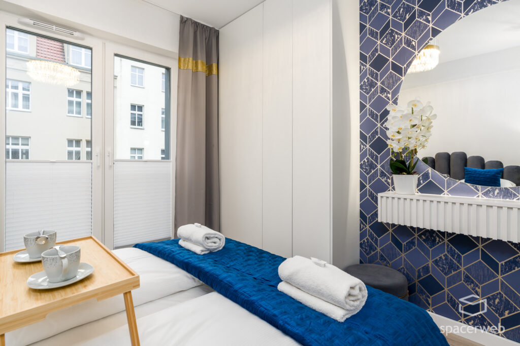 Fotografia wnętrz - łazienka, duże lutro, sypialnia, granatowe narzuty, krótkoterminowy