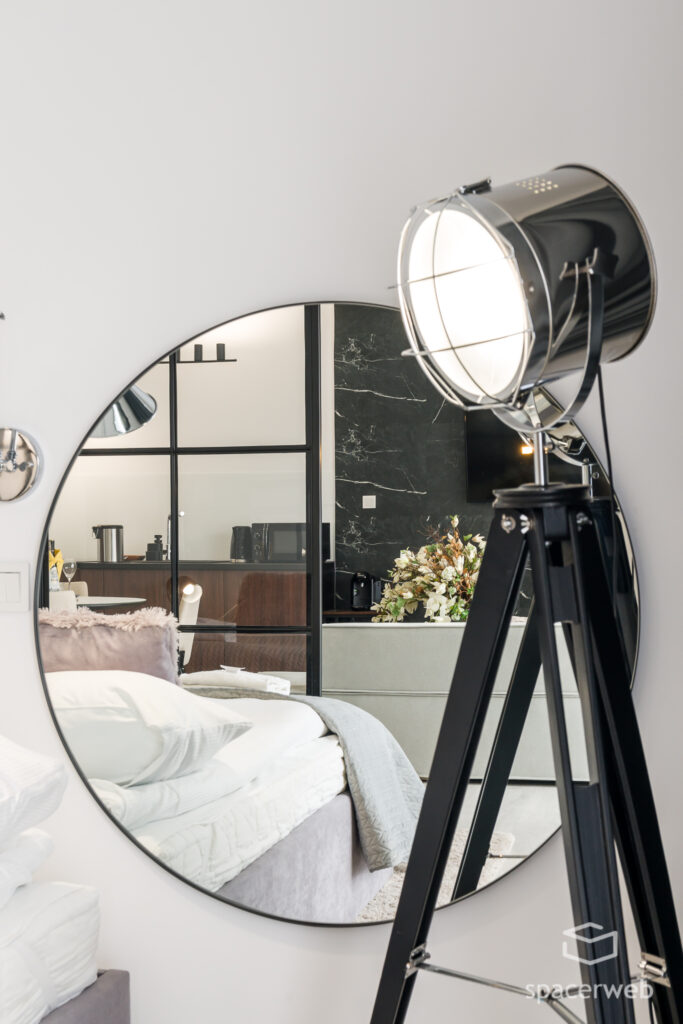 Fotografia wnętrz - Sypialnia, duże lustro, lampa na trójnogu