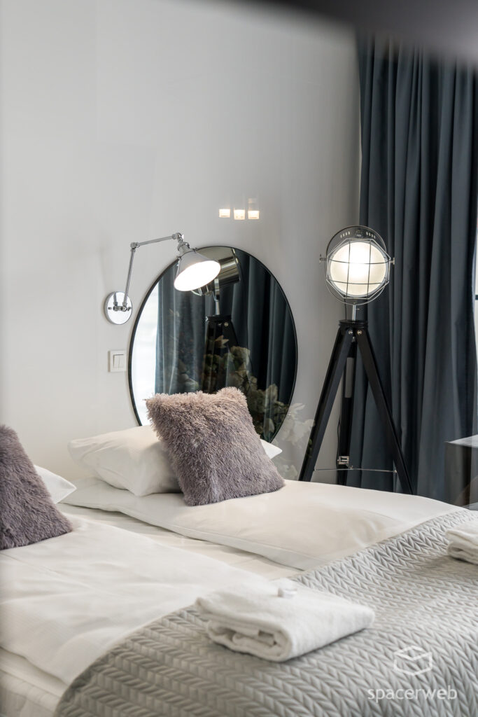 Fotografia wnętrz - Sypialnia, duże lustro, lampa na trójnogu