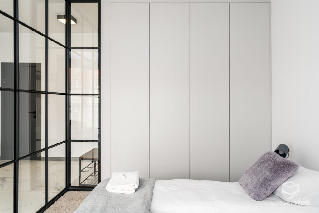 Fotografia wnętrz - Sypialnia, duże lustro, lampa na trójnogu