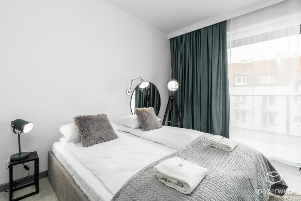 Fotografia wnętrz - Sypialnia, duże lustro, lampa na trójnogu